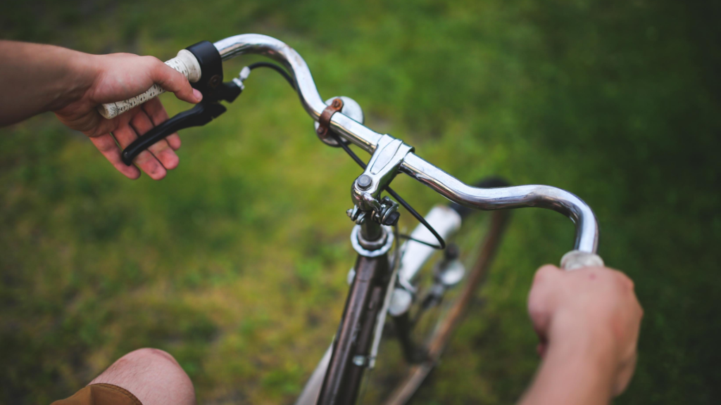 It's easy to exercise for happiness. Get on your bike! A person's hands shown holding the handle bars of their bike.
